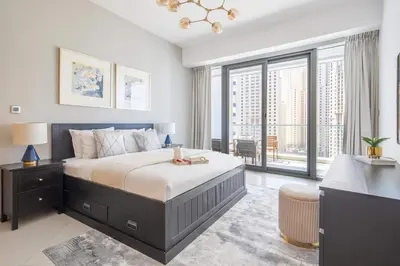 a bedroom with a bed with a desk and a window at Frank Porter - Trident Grand in Dubai