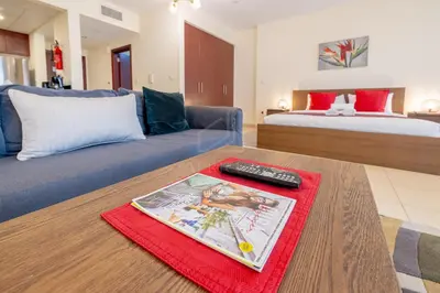 a living room with a couch and a bed at Modern and new studio in Murjan, JBR in Dubai