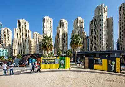 a yellow building in front of a city with tall buildings at Modern and new studio in Murjan, JBR in Dubai