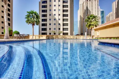 a large swimming pool in a city with tall buildings at Modern and new studio in Murjan, JBR in Dubai