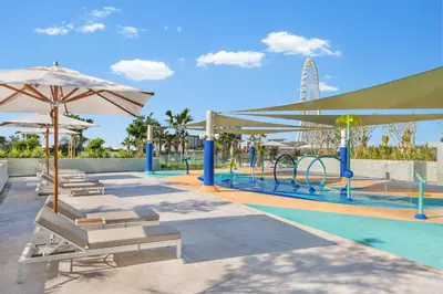 a pool with chairs and an amusement park at Address Beach Resort in Dubai