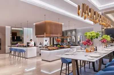 a restaurant with tables and a kitchen with a chef at Address Beach Resort in Dubai