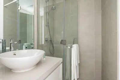 a bathroom with a white sink and a shower at Frank Porter - Studio One in Dubai