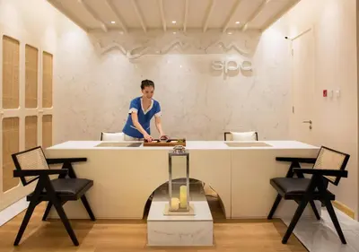 a man standing in a kitchen with a counter at Dusit Thani Dubai in Dubai