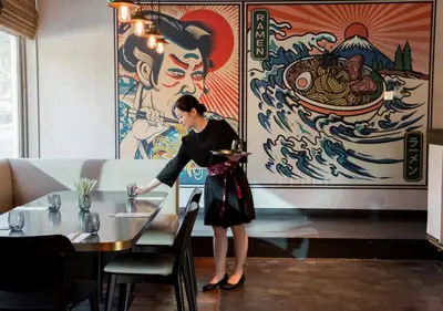 a woman standing at a table in a restaurant at Dusit Thani Dubai in Dubai