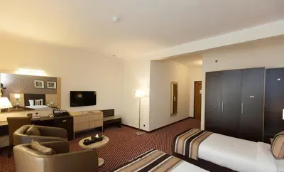 a hotel room with a bed and a living room at Fortune Karama Hotel in Dubai