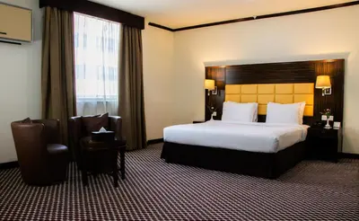 a hotel room with a large bed and a window at Fortune Karama Hotel in Dubai