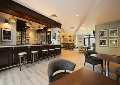 a bar in a restaurant with tables and chairs at Arabian Park Dubai, an Edge by Rotana Hotel in Dubai