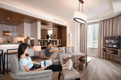 a man and a woman sitting in a living room at Towers Rotana - Dubai in Dubai