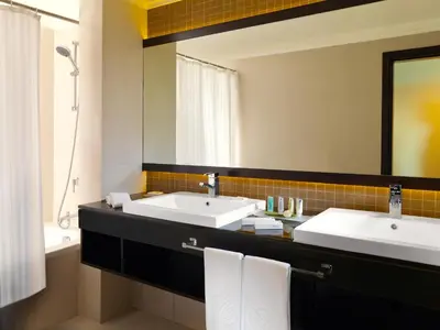 a bathroom with two sinks and a large mirror at Towers Rotana - Dubai in Dubai