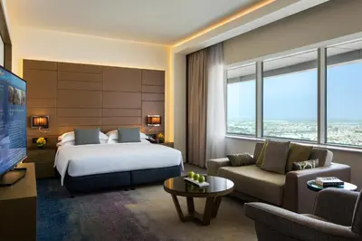 a hotel room with a bed and a couch at Towers Rotana - Dubai in Dubai