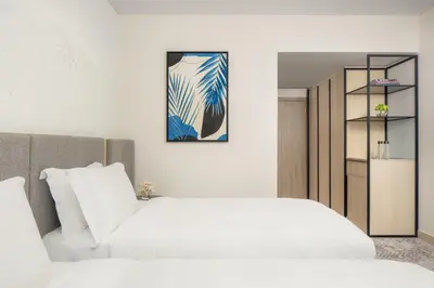 a bedroom with two beds and a book shelf at Towers Rotana - Dubai in Dubai