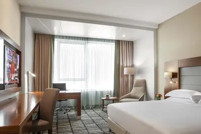 a hotel room with a bed and a desk and a bedroom at Jumeira Rotana – Dubai in Dubai
