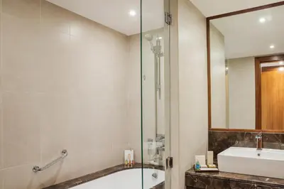 a bathroom with a tub and a sink and a mirror at Jumeira Rotana – Dubai in Dubai