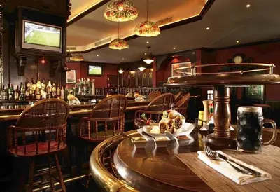 a restaurant with a bar with a table and chairs at Jumeira Rotana – Dubai in Dubai