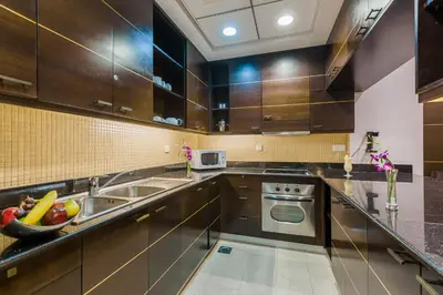 a kitchen with stainless steel appliances and brown cabinets at Park Apartments Dubai, an Edge By Rotana Hotel in Dubai