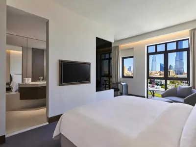 a bedroom with a large white bed and a bathroom at The Heritage Hotel, Autograph Collection, Downtown Dubai in Dubai
