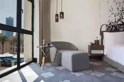 a bedroom with a bed and a chair and a window at The Heritage Hotel, Autograph Collection, Downtown Dubai in Dubai