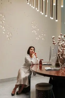 a woman sitting at a desk in front of a computer at The Heritage Hotel, Autograph Collection, Downtown Dubai in Dubai