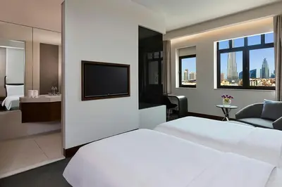 a hotel room with a white bed and a television at The Heritage Hotel, Autograph Collection, Downtown Dubai in Dubai