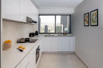 a kitchen with white cabinets and a large window at Staybridge Suites Dubai Financial Centre by IHG in Dubai