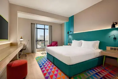 a hotel room with a large bed and a desk at La Quinta by Wyndham Dubai Jumeirah in Dubai