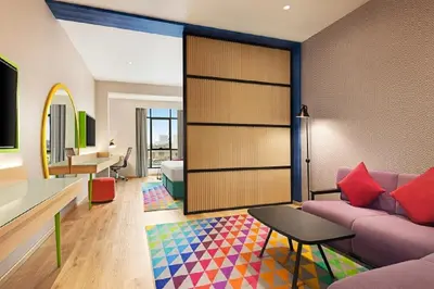 a living room with a purple couch and a bedroom at La Quinta by Wyndham Dubai Jumeirah in Dubai