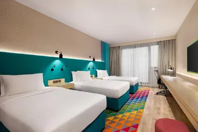 a hotel room with three beds and a flat screen tv at La Quinta by Wyndham Dubai Jumeirah in Dubai