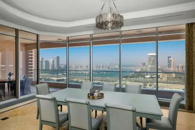 a dining room with a table and chairs and a large window at Al Habtoor Grand Resort, Autograph Collection in Dubai