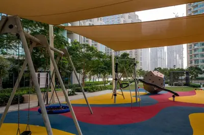 a playground in a city with a slide and swings at Spacious 3BR in Downtown, Direct Access to Dubai Mall & Metro, Burj Khalifa Views in Dubai