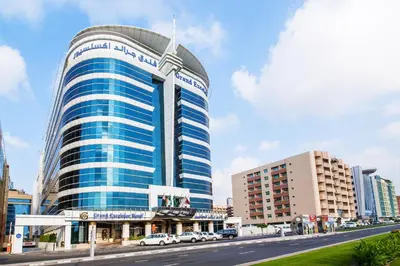 a tall building with cars parked in front of a street at Grand Excelsior Hotel Bur Dubai in Dubai