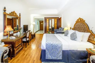 a hotel room with a large bed and a desk at Grand Excelsior Hotel Bur Dubai in Dubai
