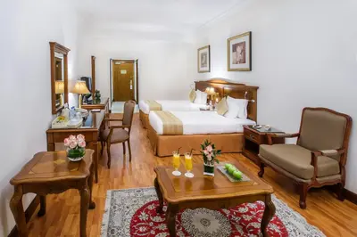 a hotel room with a bed and a living room at Grand Excelsior Hotel Bur Dubai in Dubai