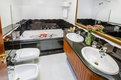 a bathroom with two sinks and a bath tub at Grand Excelsior Hotel Bur Dubai in Dubai