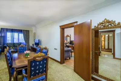 a room with a dining table and a living room at Grand Excelsior Hotel Bur Dubai in Dubai