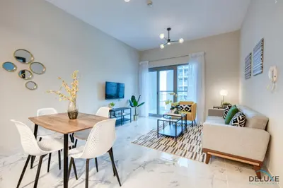 a living room with a table and chairs at Distance Away From Expo City Dubai 1BR Unit, MAG 510, Madinat Al Mataar by Deluxe Holiday Homes in Dubai