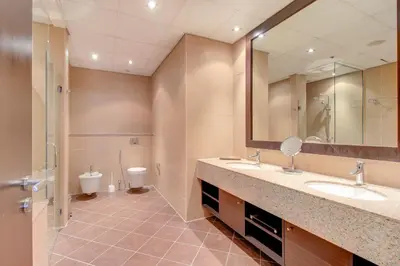 a bathroom with two sinks and a toilet at Luxe Getaways Royal Amwaj Palm Jumeirah Resort Apartment Holiday Home in Dubai