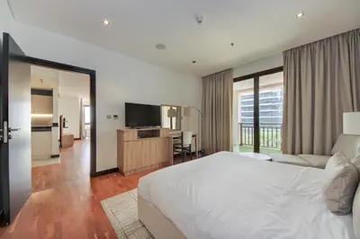 a hotel room with a bed and a television at Luxe Getaways Royal Amwaj Palm Jumeirah Resort Apartment Holiday Home in Dubai