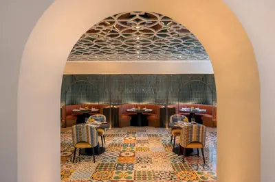 an archway in a restaurant with tables and chairs at Avani Plus Palm View Dubai Hotel & Suites in Dubai