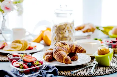 a table topped with plates of pastries and fruit at Avani Plus Palm View Dubai Hotel & Suites in Dubai