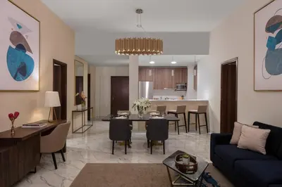 a living room with a couch and a dining room at Avani Plus Palm View Dubai Hotel & Suites in Dubai