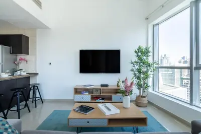a living room with a flat screen tv on a white wall at The Smart Concierge - Bay Central in Dubai