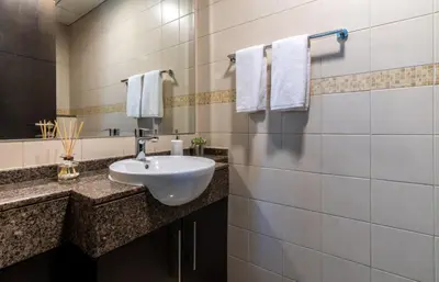 a bathroom with a white sink and a mirror at The Smart Concierge - Bay Central in Dubai