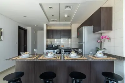 a kitchen with a center island with bar stools at The Smart Concierge - Bay Central in Dubai