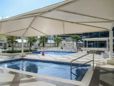 a large pool with a large tan umbrella at The Smart Concierge - Bay Central in Dubai