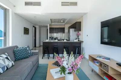 a living room with a couch and a table with flowers at The Smart Concierge - Bay Central in Dubai