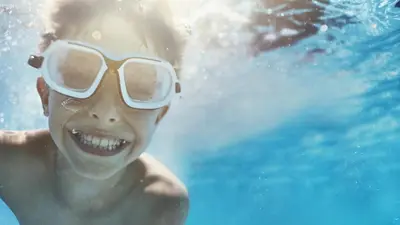 a young boy wearing goggles in the water at Millennium Plaza Downtown, Dubai in Dubai