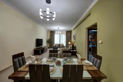a dining room and living room with a table and chairs at Radiance Premium Suites in Dubai