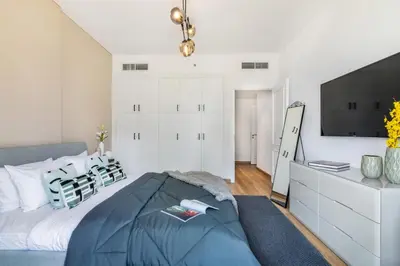 a bedroom with a large bed and a tv at The Smart Concierge - Royal Oceanic in Dubai