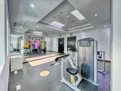 a gym with a treadmill and people in the background at The Smart Concierge - Royal Oceanic in Dubai